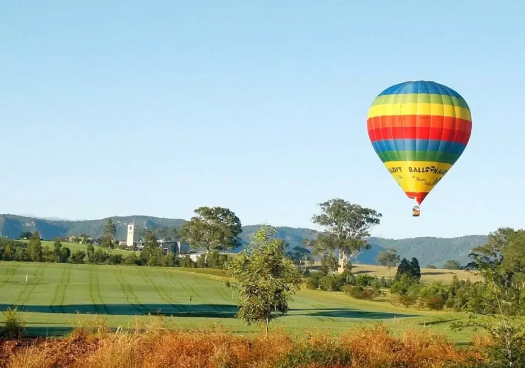 Rainbow coloured hot air balloon above Rothbury